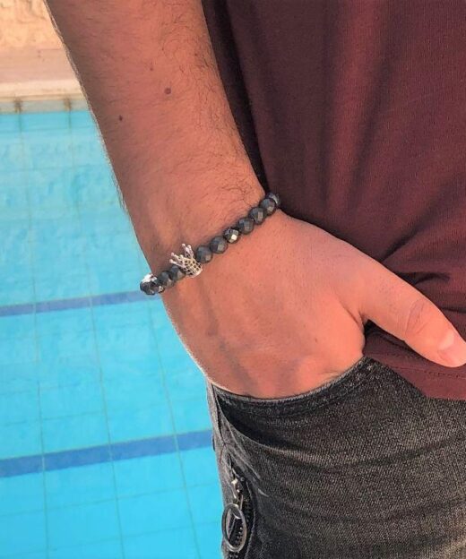 תמונה של דוגמן בבריכה עם צמיד לגברים בצבע אפור עם כתר משובץ