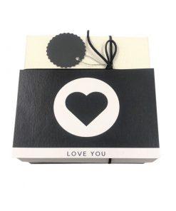 תמונה של קופסת מתנה בצבע שחור לבן עם כרטיס ברכב לב
