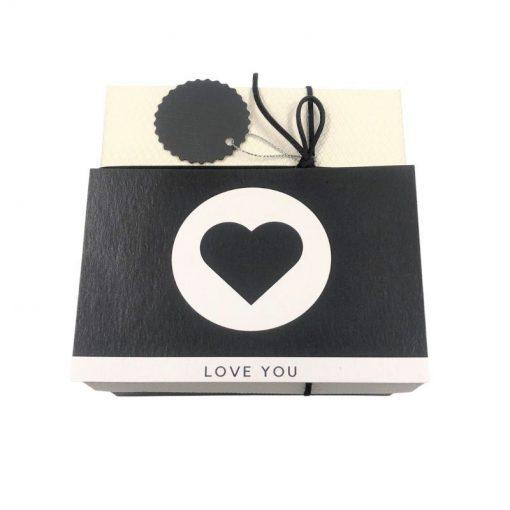 תמונה של קופסת מתנה בצבע שחור לבן עם כרטיס ברכב לב
