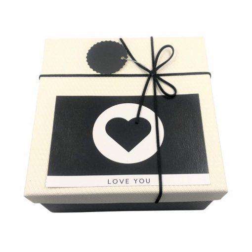 תמונה של קופסת מתנה גדולה בצבע שחור לבן עם כרטיס ברכה